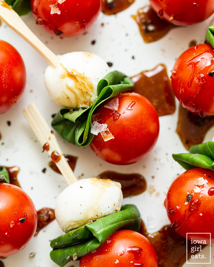 close up photo of a caprese skewer drizzled with balsamic reduction