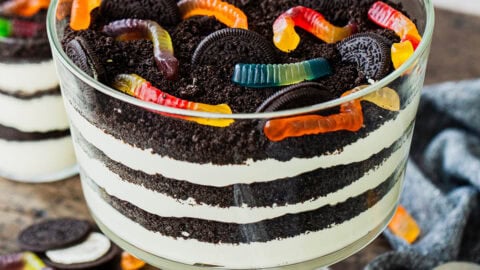 dirt cake topped with gummy worms in a trifle bowl