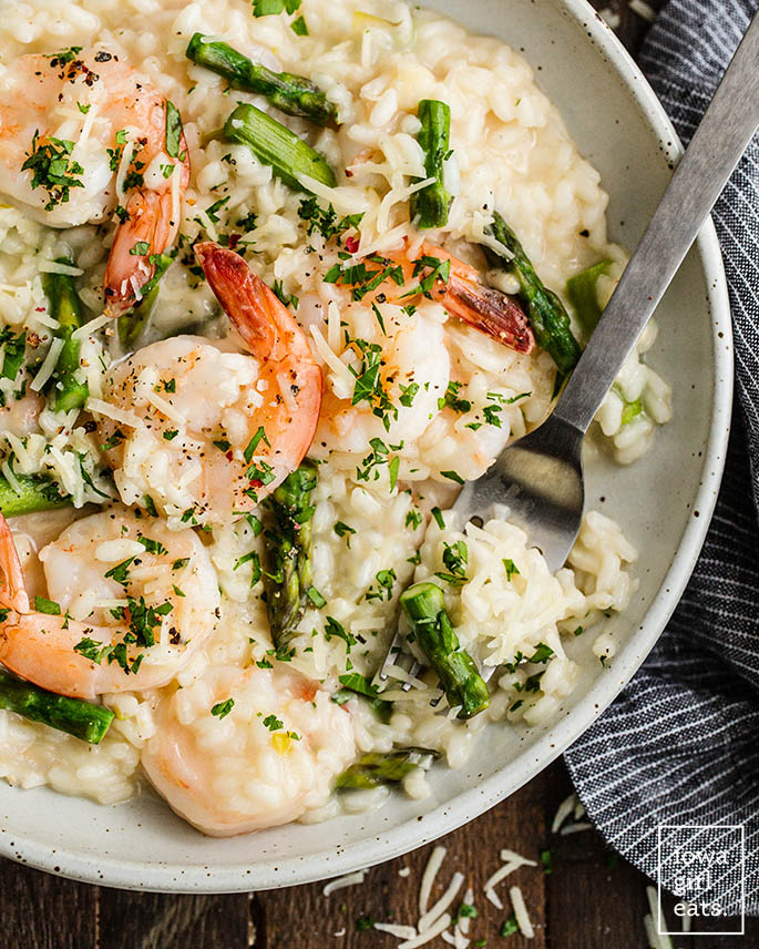 fork in a bowl of shrimp and asparagus risotto