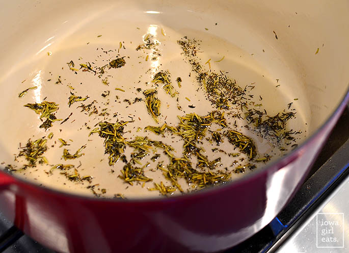 dried herbs being sauteed in a dutch oven