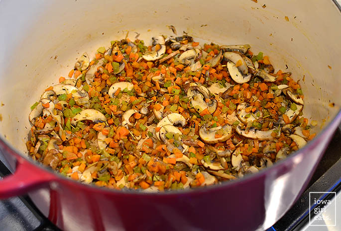 vegetables being sauteed in a dutch oven