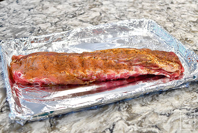 seasoned rib rack on a baking sheet