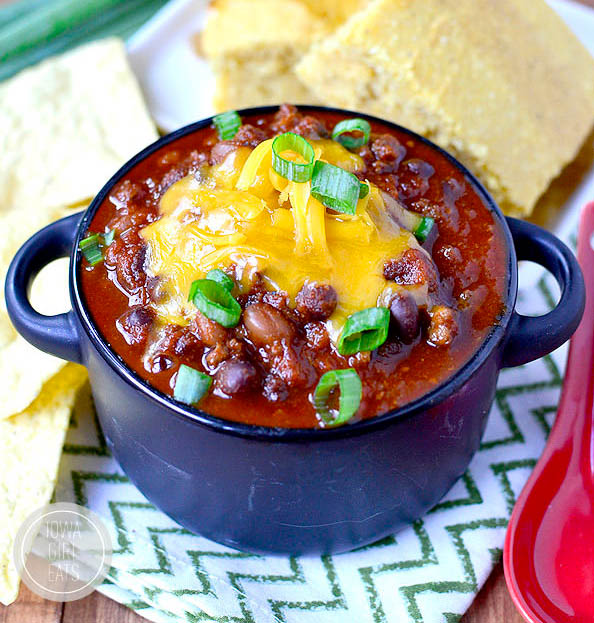 bowl of chili with cheese and cornbread