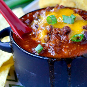 spoon dunked into a bowl of signature chili