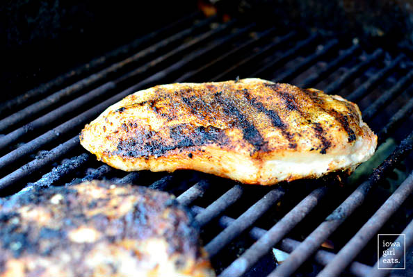chicken breasts grilling on a grill