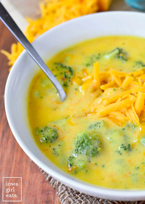 spoon resting inside a thick and cheesy bowl of broccoli cheddar soup