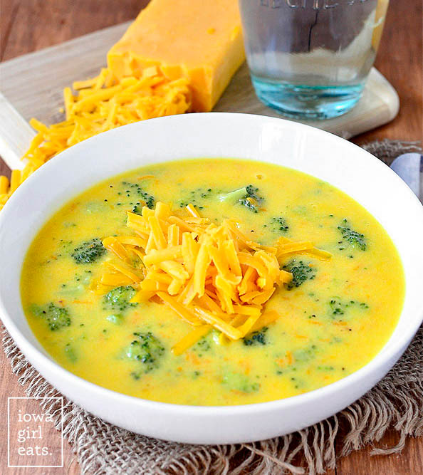 a bowl of perfect broccoli cheese soup with shredded cheddar on top
