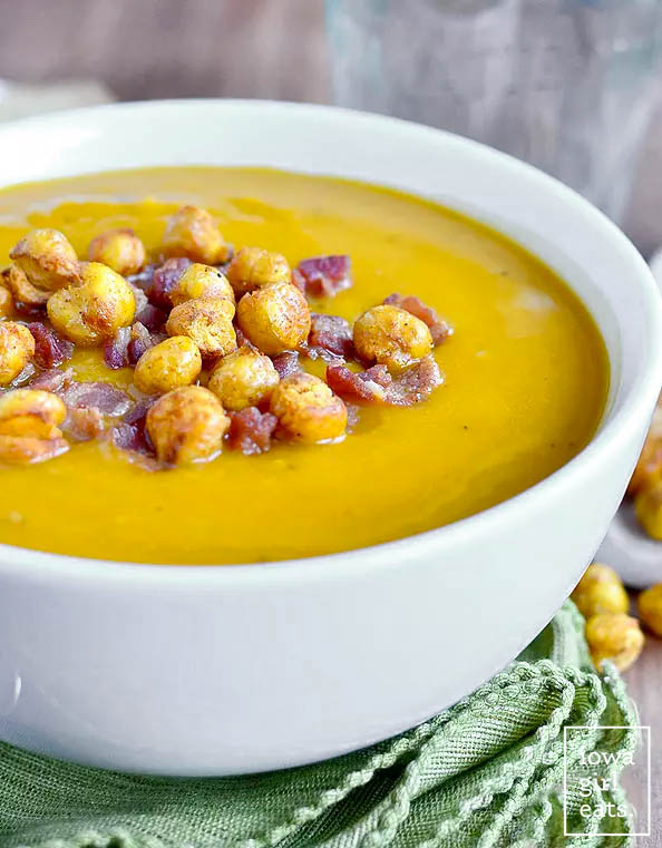 roasted butternut squash soup in a bowl with bacon and crispy chickpeas