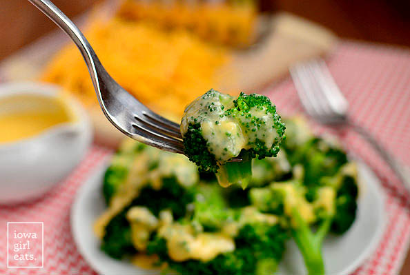 fork with a cooked piece of broccoli and cheese sauce
