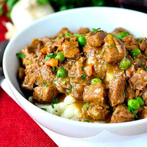 luscious beef stew over mashed potatoes in a bowl