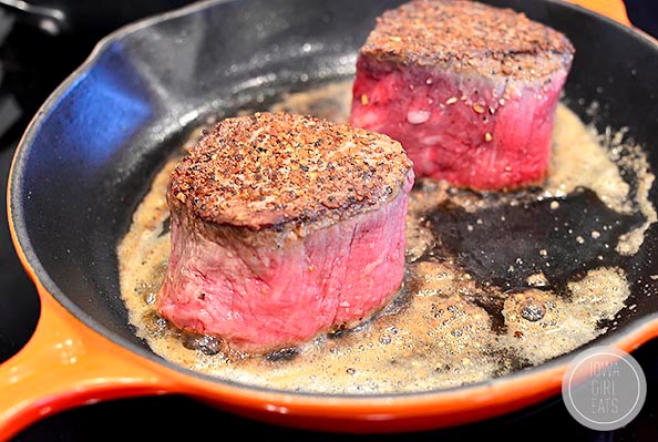 filet mignons searing in butter in a skillet