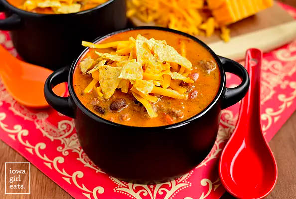 crock of cheesy taco soup with chips and cheese on top