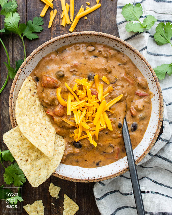 overhead photo of bowl of cheesy taco soup with tortilla chips and cheese