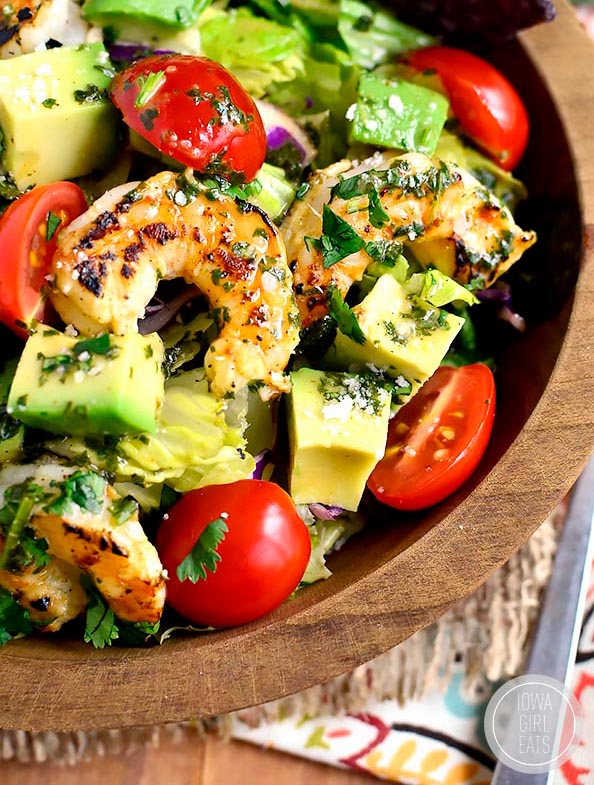 wooden serving bowl of Shrimp and Avocado Taco Salad with dressing