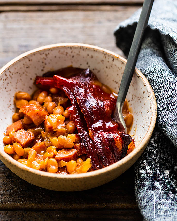 baked beans with bacon in a bowl with a spoon