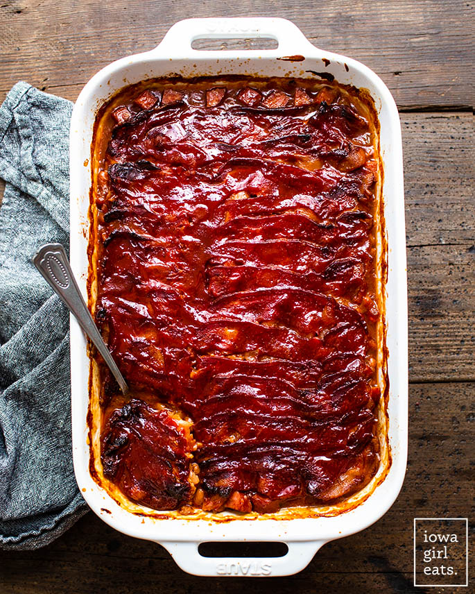 pan of best baked beans with caramelized bacon on top