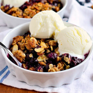 gluten free blueberry crisp in a bowl with ice cream