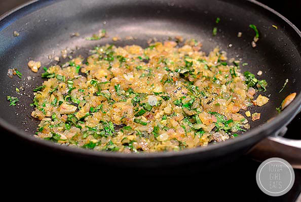 shallots and herbs sauting in a skillet