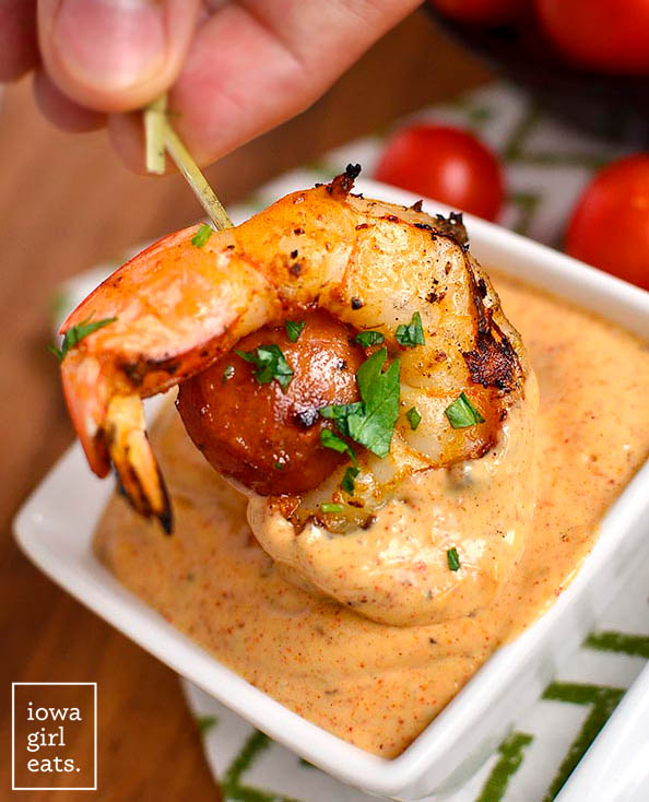 Shrimp and Sausage Skewer dunked into dipping sauce