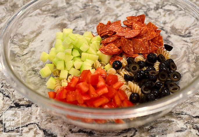 ingredients for the best pasta salad in a mixing bowl