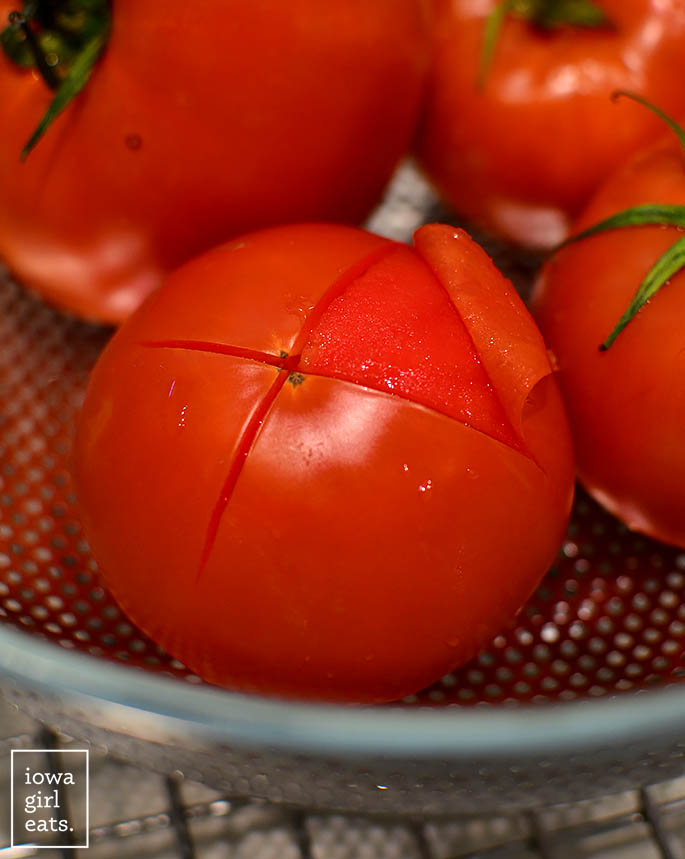 peeling the skin off a blanched tomato