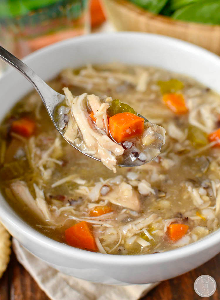 spoon scooping up chicken and wild rice soup made in the slow cooker