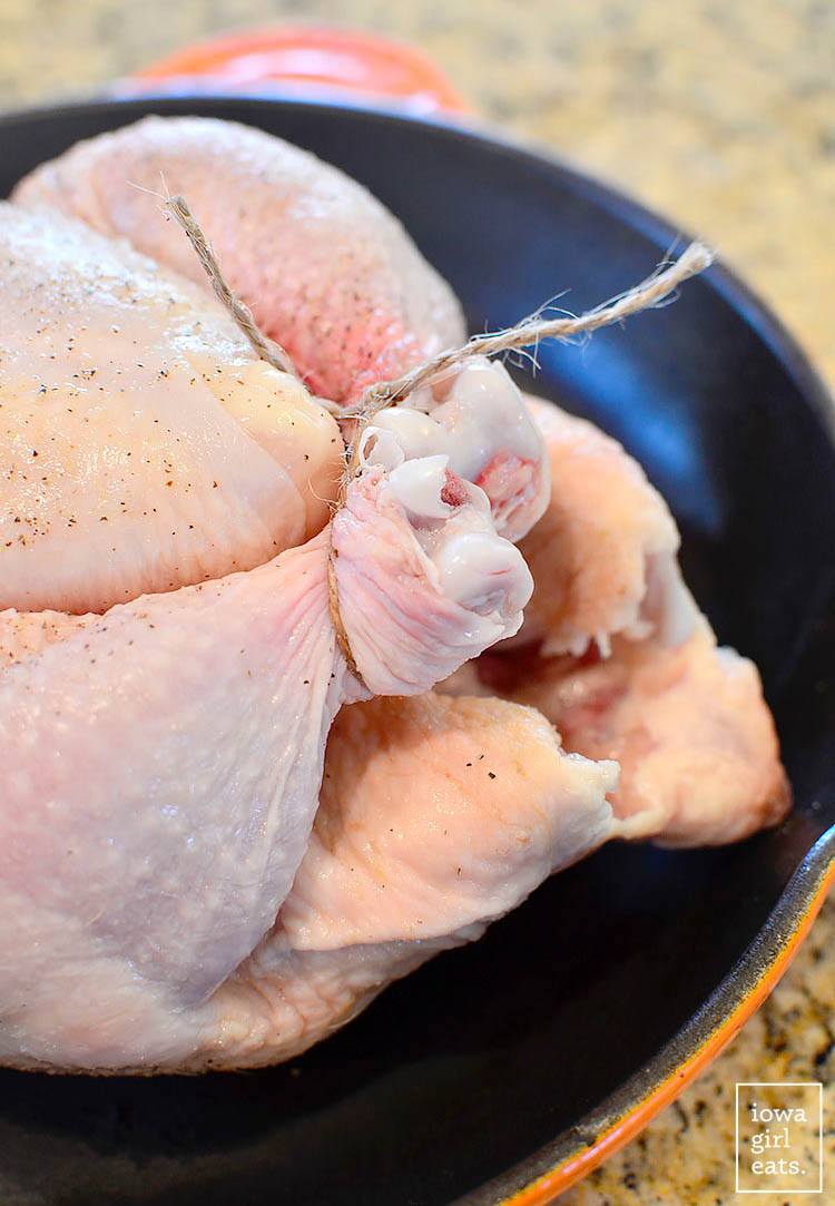 chicken legs held together by twine in a cast iron skillet