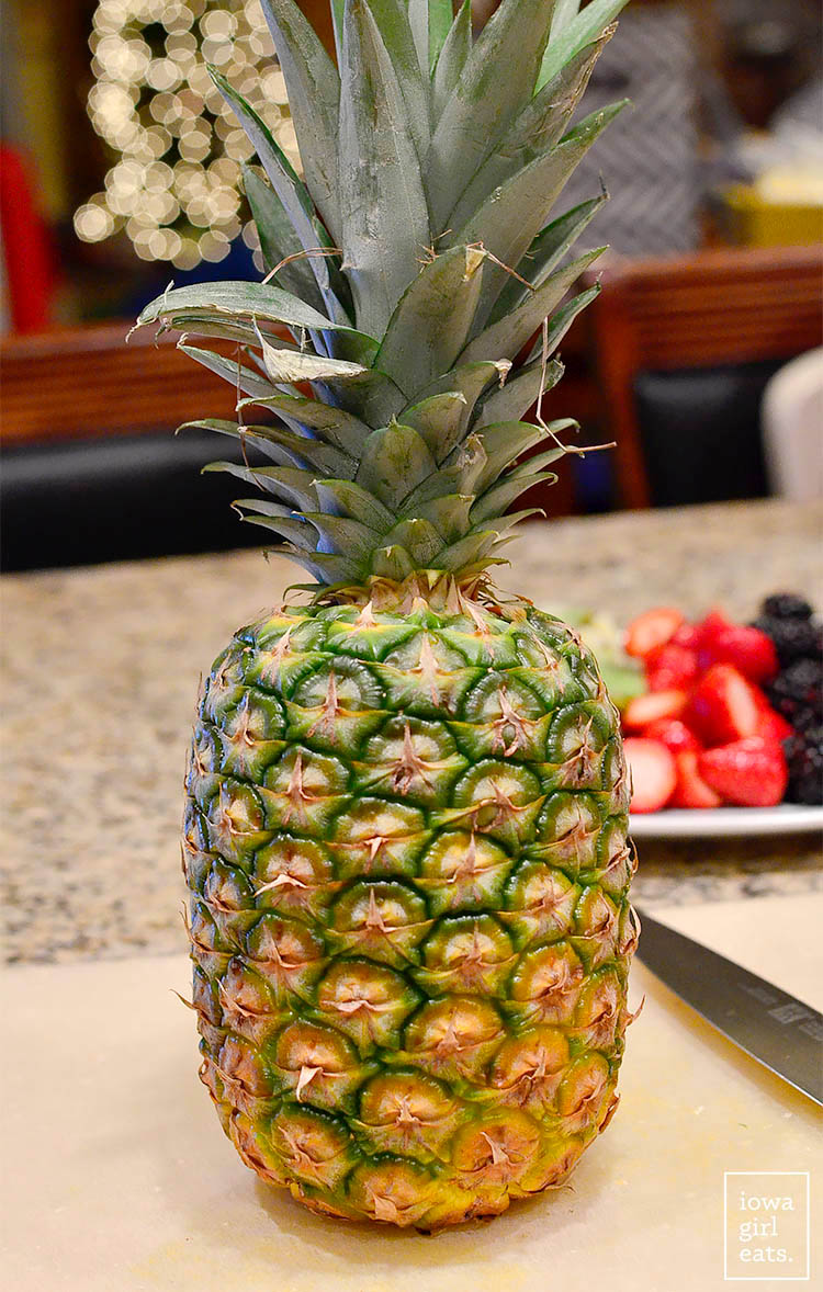 whole pineapple sitting on a cutting board