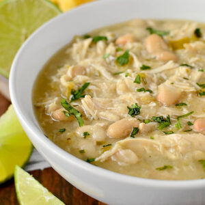 bowl of crock pot white chicken chili with lime wedges