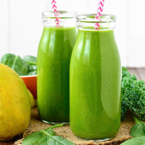 green smoothies in glass jars with straws