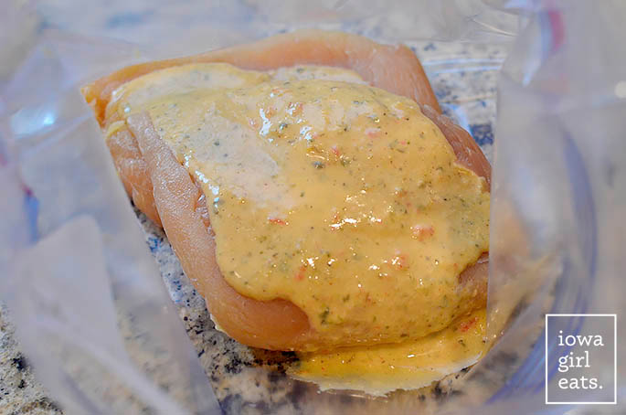 chicken breasts marinating in caesar dressing in a bag