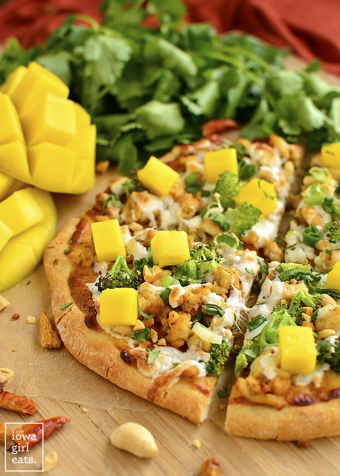 Switch up pizza night with gluten-free Thai Chicken Flatbread Pizzas featuring a savory peanut sauce, fresh herbs, and sweet mango. | iowagirleats.com