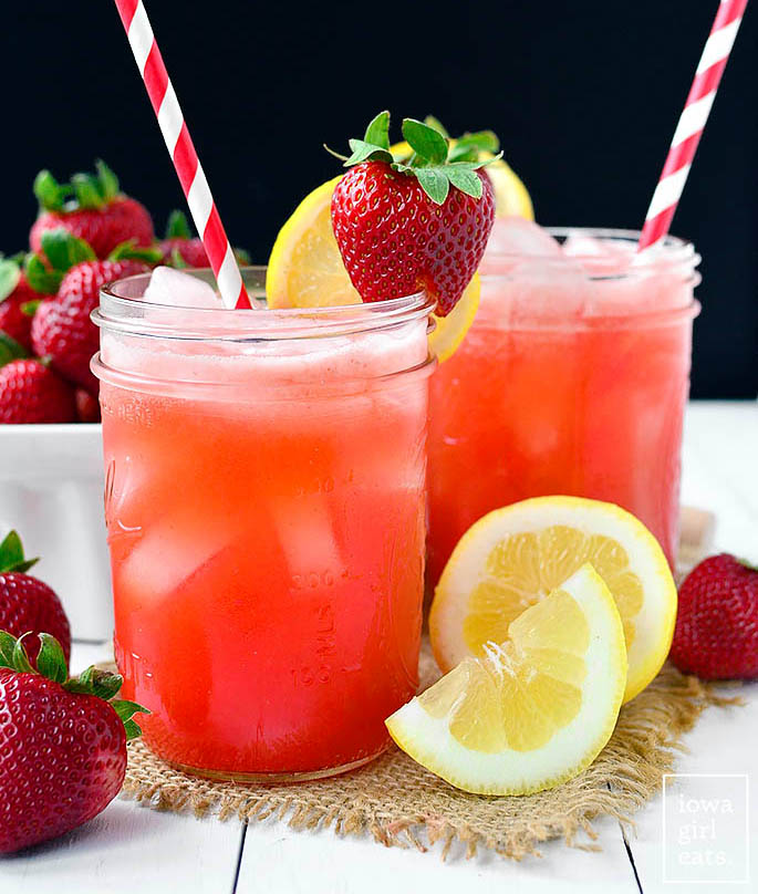 glasses of strawberry coconut water lemonade with lemons and strawberries