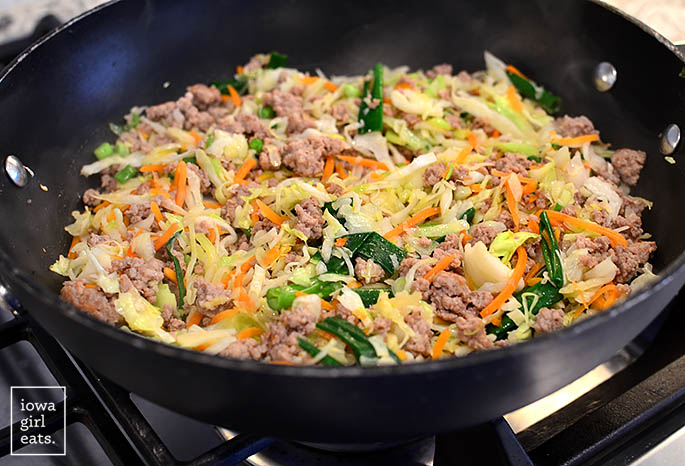ground pork and vegetables cooking in a wok