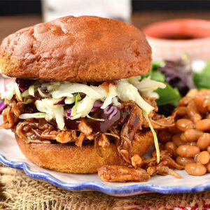 a sandwich on a plate with gluten free crock pot bbq pulled pork