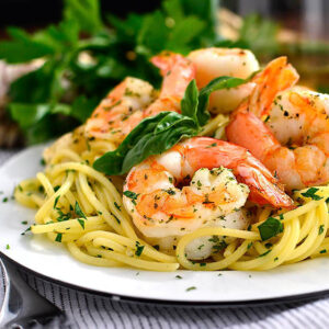 roasted shrimp nestled onto a plate of garlic herb butter pasta