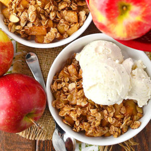 overhead photo of apple crisp in bowls with ice cream scoops
