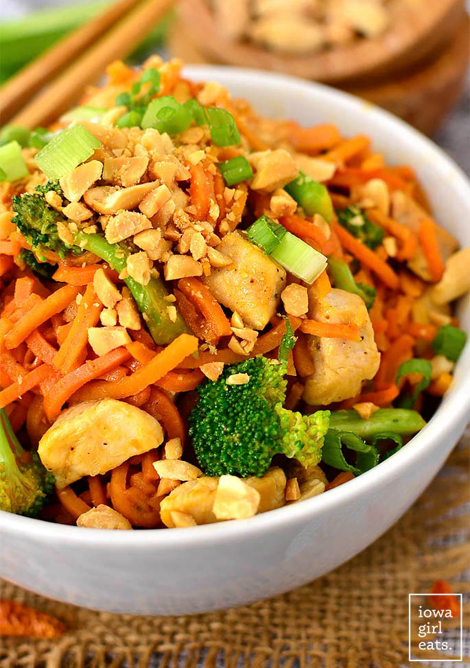 a bowl of thai peanut chicken sweet potato noodles with crushed peanuts on top