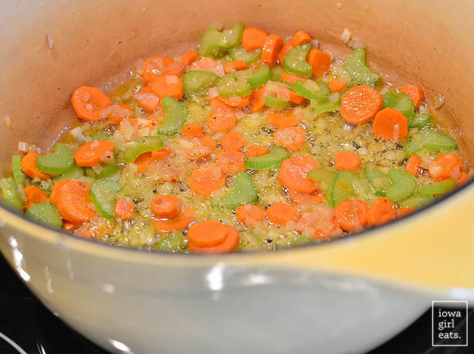 chopped vegetables sauting in butter in a dutch oven