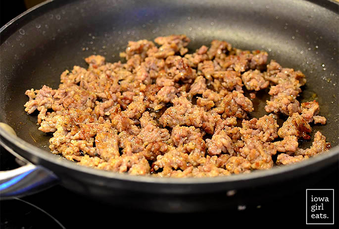 italian sausage browning in a hot skillet