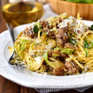 plate of sausage brussels sprouts and parmesan pasta with a fork