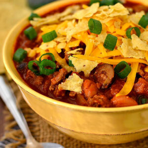 bowl of taco chili with crushed tortilla chips and green onions on top