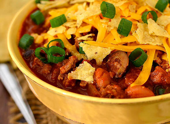 bowl of taco chili with crushed tortilla chips and green onions on top