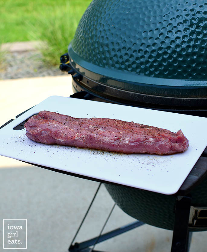 pork tenderloin on a cutting board near a grill