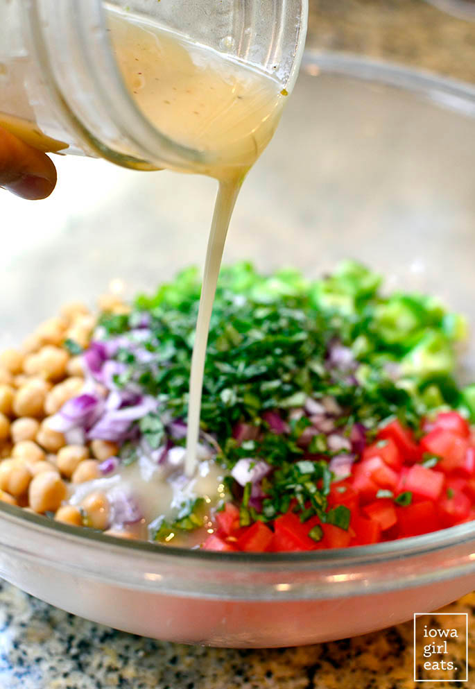dressing being poured onto italian chickpea salad