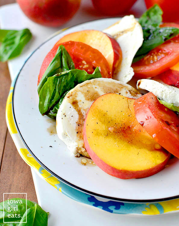 fresh peach slices layered with tomatoes mozzarella and fresh basil
