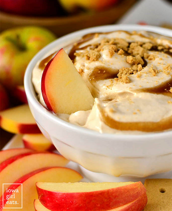 apple slice tucked into a bowl of caramel apple cheesecake dip