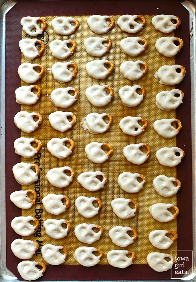 white chocolate dipped mini pretzels on a baking pan