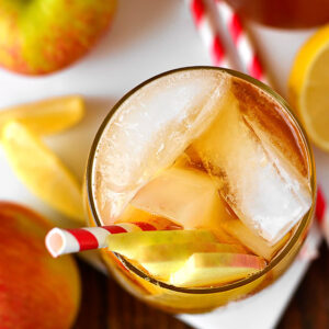 overhead photo of a sparkling maple bourbon cider in a glass with apple garnish