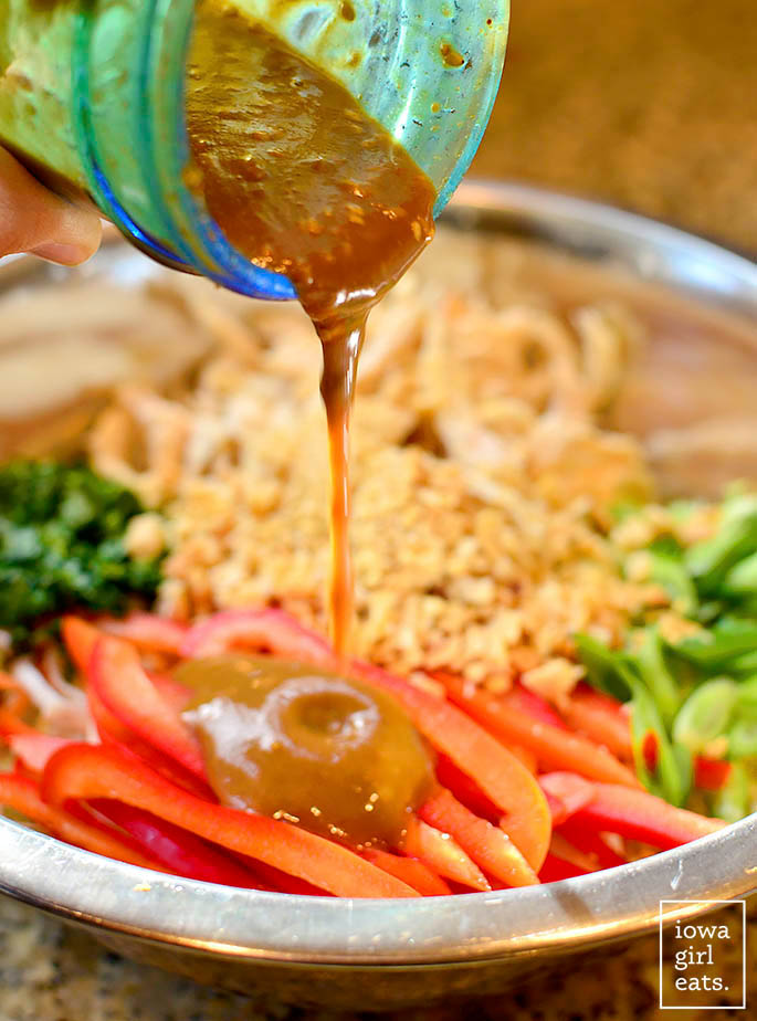 peanut dressing drizzled over a bowl of thai crunch salad